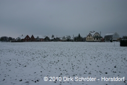 Blick &uuml;ber ein verschneites Feld zur Kesselgasse in Kakau am Neujahrstag 2010.